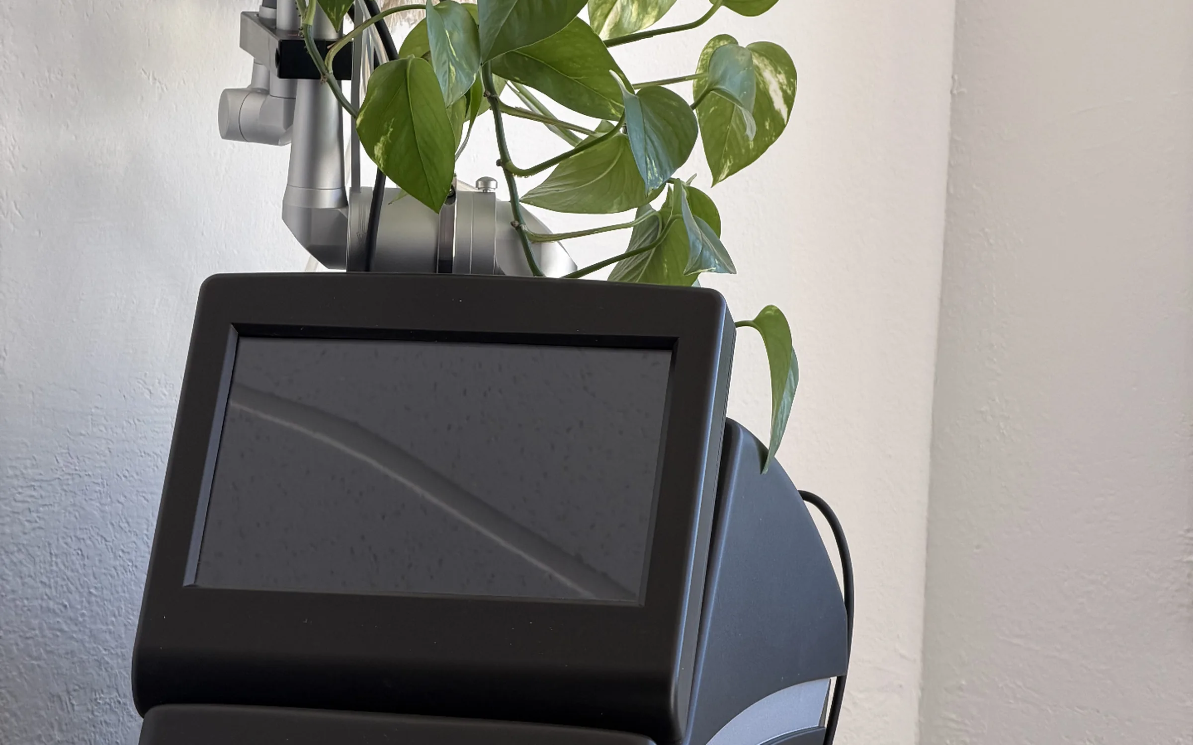 Alma laser platform styled with white orchids in the treatment room